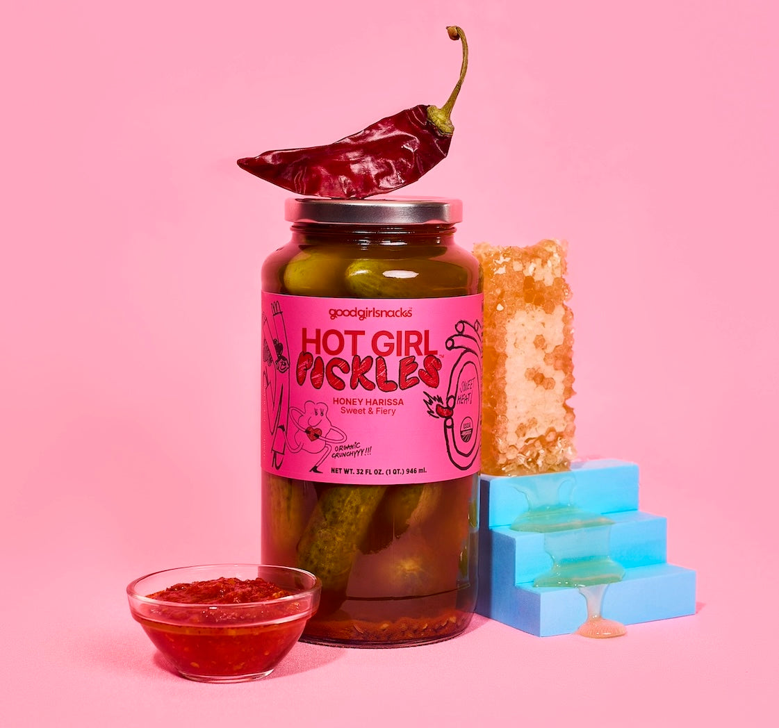 The Hot Girl Pickles flavor honey harissa surrounded by dripping honeycomb, red chili sauce, and a red chili pepper.